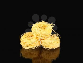  raw dry nest pasta with reflection  on black