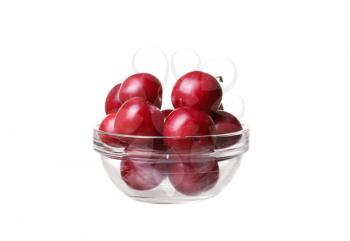 Plums in a glass bowl on white isolate
