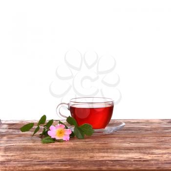 Cup of tea and dog rose on white background