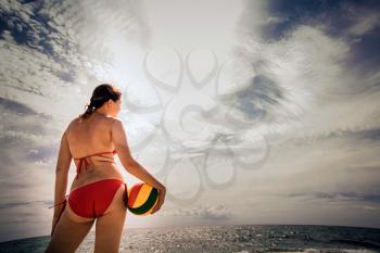 healthy young woman laughing with beachball while on the beach in summer. vacation, sport and people concept - young woman with ball playing volleyball