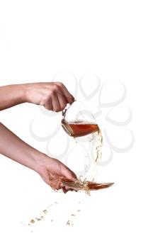 Brown splashes out drink from glass on a white background.