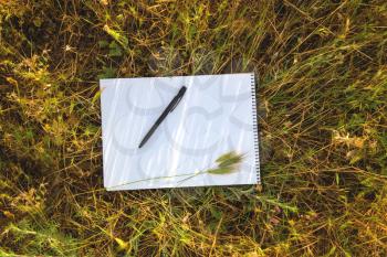 Notebook on fresh spring green grass in field