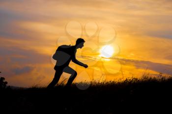 Follow your dreams, silhouette of man at sunset. Hiker with backpack walking in the field. Over sunset. Summer healthy active lifestyle. Single travel.