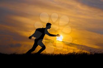 Follow your dreams, silhouette of man at sunset. Hiker with backpack walking in the field. Over sunset. Summer healthy active lifestyle. Single travel.