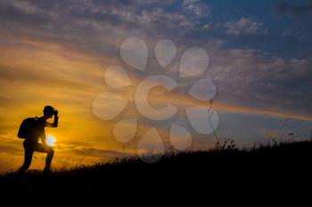 Follow your dreams, silhouette of man at sunset. Hiker with backpack walking in the field. Over sunset. Summer healthy active lifestyle. Single travel.