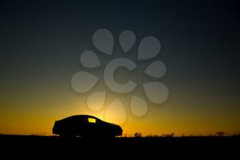 Silhouette of sedan car on the background of beautiful sunset