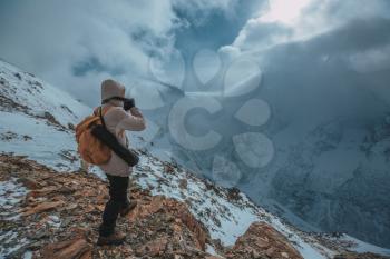 High mountains under snow in the winter. A series of photos of the Caucasus Mountains, ski resort Dombay, Karachay-Cherkessia. Man take photo of great view