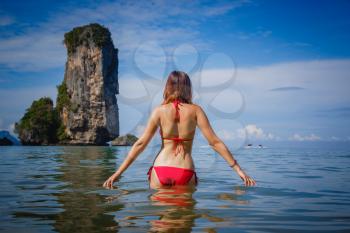 portrait of woman in red swim suit relaxing on tropical beach. Vacation at Paradise. Ocean beach relax, travel to Thailand, Krabi