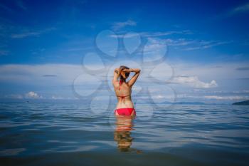 portrait of woman in red swim suit relaxing on tropical beach. Vacation at Paradise. Ocean beach relax, travel to Thailand, Krabi