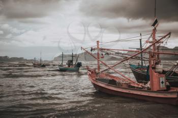 Coastal fishing boats at low tide in summer of Thailand
