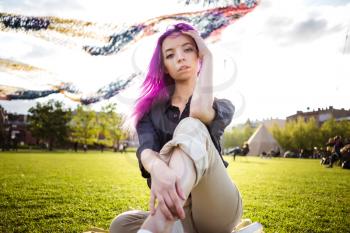 Beautiful young violet hairy girl walking at sunset in a city park. St. Petersburg, New Holland