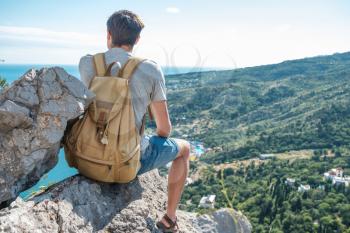 Tourist with backpack enjoy valley view from top of a mountain. Crimea, Mount Cat