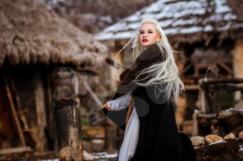 Beautiful young woman holding a viking with blond hair. Image of Historical figure