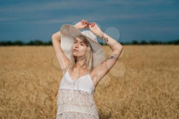 nature, summer holidays, vacation and people concept - face of happy smiling woman or teenage girl n in hat on cereal field