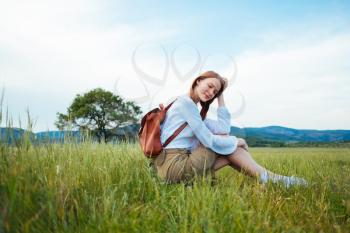 woman traveler with backpack and hat walking, wanderlust travel concept, space for text, atmospheric moment. earth day