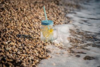 mojito on summer sandy beach. Mojito in glass jars on the sea coast. summer beach fun in the sea
