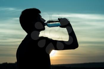 Rehydrate your body. male drinking a bottle of water.
