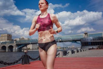 professional young female runner player running in park for training personal speed and explosive force at holiday weekend. The idea and concept of healthy lifestyle in a big city. Moscow Gorky Park