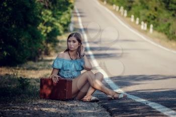 Young beautiful Asian woman in hippy style. travels by hitchhiking. Road in the mountains