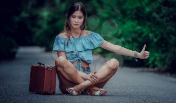 Young beautiful Asian woman in hippy style. travels by hitchhiking. Road in the mountains