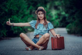 Young beautiful Asian woman in hippy style. travels by hitchhiking. Road in the mountains