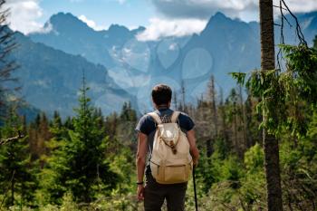 Man hiking at mountains with heavy backpack Travel Lifestyle wanderlust adventure concept summer vacations outdoor alone into the wild. Tatra National Park, Poland