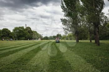 mower cutting the grass in public park. park Kolomenskoye in spring Moscow