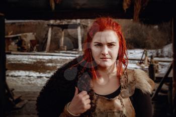 Viking girl. Reconstruction of a medieval scene. Against the backdrop of a large viking village.