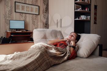 Sick and Flu Woman. Caught Cold. Woman feeling cold with blanket resting on the sofa at home