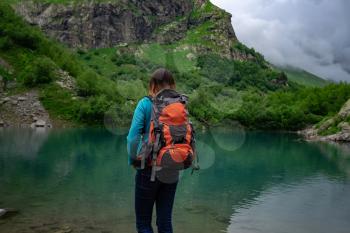 Traveler look at the mountain lake. Travel and active life concept. Adventure and hiking in the mountains region in the North Caucasus, Dombai, RussiaNorth Caucasus, Dombai, Russia