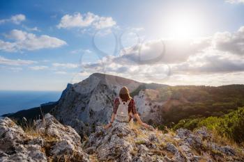 woman hiker enjoy the view at sunset mountain peak cliff. idea of ecotourism travel. Discovery Travel Destination Concept