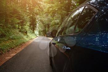 Blue car on beautiful way with the background of the road to forest. season car trip road travel concept. cinematic photography film grain tone style