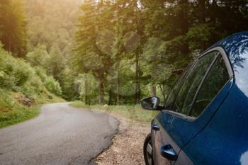 Blue car on beautiful way with the background of the road to forest. season car trip road travel concept. cinematic photography film grain tone style