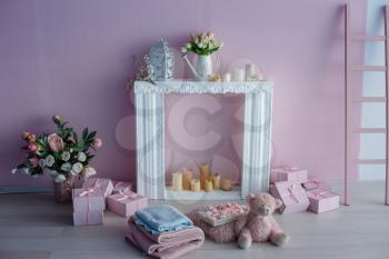 luxury clean bright white interior. a spacious room with sunlight and flowers in vases, with a decorative fireplace, cute pink plaids, and a vase with marshmallows. Idea and concept of a girl's room
