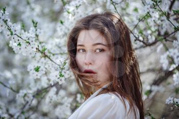 young asian woman in a flowering garden. romantic image of stylish casual woman , trendy silk blouse. positive mood. Cheery Blossom full bloom in Japan.