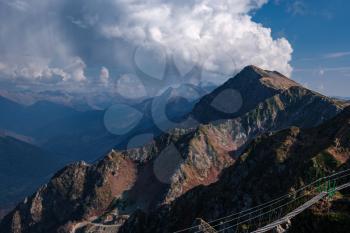 Autumn in the North Caucasus, Rosa Khutor ski resort in off-season. Russia, Sochi. Vintage toning. Travel background. Dramatic sky, sunset time, beautiful heavy clouds.