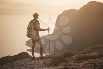 Man hiking at sunset mountains with heavy backpack. Travel Lifestyle wanderlust adventure concept summer vacations outdoor alone into the wild. mock up text.