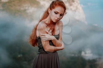 beautiful furious scandinavian warrior ginger woman in grey dress with metal chain mail. Woman is a Viking. Fantasy. Book Cover. Close-up portrait. Cinematic look