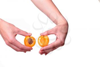 Female hand with tasty apricot on white background. Cream for hands and treatment or organic healthy food idea and concept