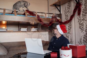 happy young man with funny gray cat at home. Christmas gift boxes, New Year winter sale discount. Safe ordering delivery at quarantine.