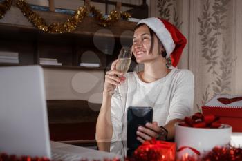 Christmas online shopping, work and education. Woman with notebook computer at home in Santa hat. Winter holidays sales, Remote Christmas video party. Family quality time during pandemic.