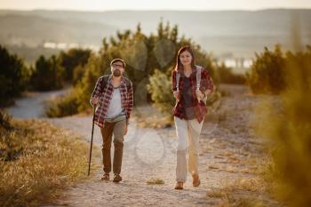 Portrait of happy young couple having fun on their hiking trip. Caucasian and asian hiker couple enjoying themselves on summer vacation. Young people hiking in nature.