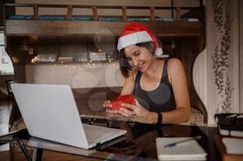 Christmas online congratulations. Smiling woman using pc computer for video call friends and parents. celebrating christmas online during coronavirus outbreak