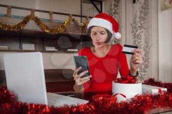Christmas woman on laptop doing internet shopping. Woman excited about buying gifts online or winning something on her laptop computer.