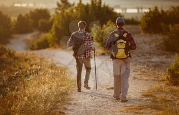 two men hikers enjoy a walk in nature, sunset time in summer. enjoying their adventure. Lifestyle hiking concept vacations outdoor