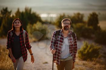 Portrait of happy young couple having fun on their hiking trip. Happy multiracial outdoors couple, young Asian woman and Caucasian man. Young people hiking in nature.