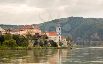 Ornate church and buildings on banks of River Danube in Durnstein, Austria
