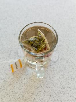 Top view of camomile or chamomile teabag in glass mug on cafe table