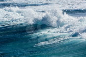 Frozen motion of large wave or breaker approaching shore and short shutter speed freezing the water into droplets