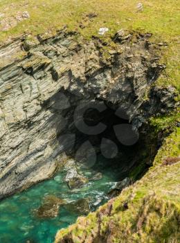 Sea cave or arch into the rock face at Tintagel, Cornwall, England, UK
